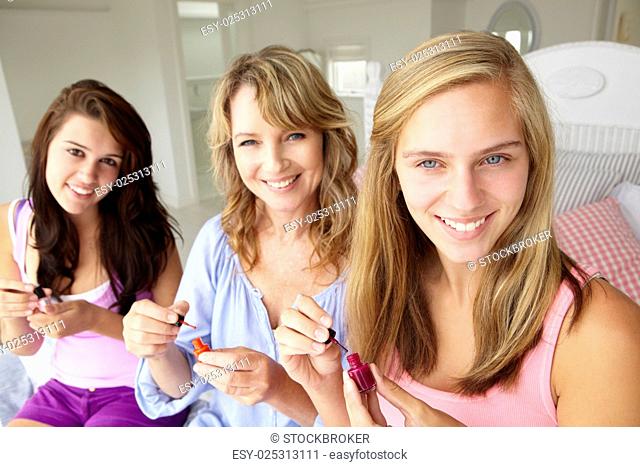 Mother and teenage daughters painting nails