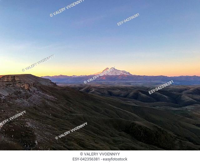 travel to North Caucasus region region - view of Mount Elbrus from Bermamyt mountain Plateau at blue dawn