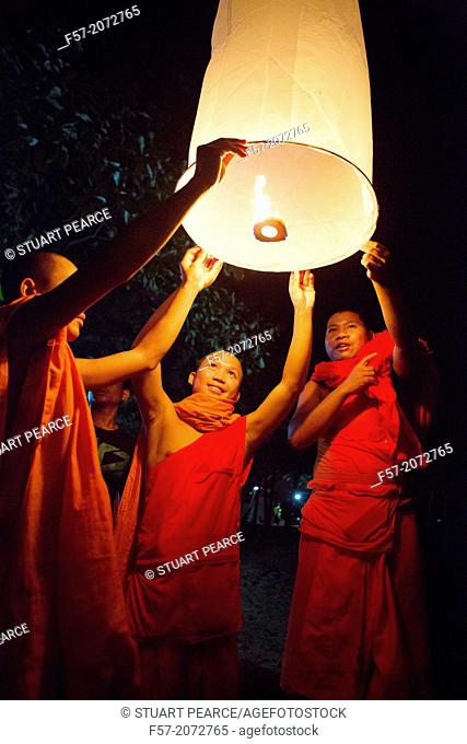 Buddhist monks lighting Chinese sky lanterns in Paske, Laos