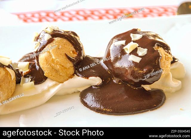 Profiteroles, Crispy hollow pastry balls filled with custard or cream then drizzled with hot chocolate