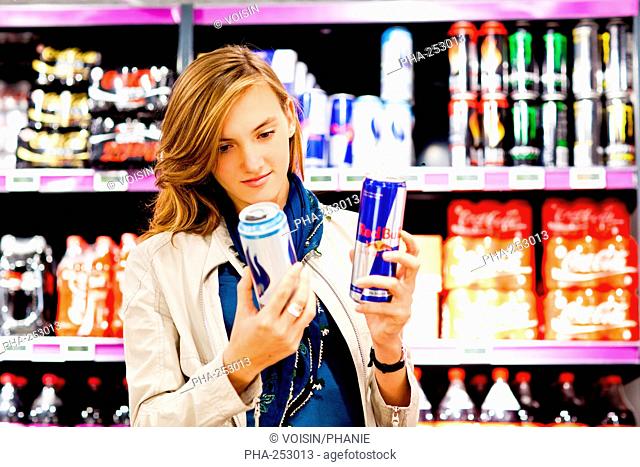 Woman shopping for energy drinks in supermarket