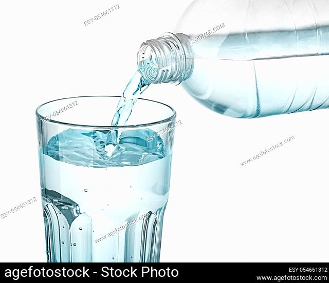 Water is poured into a glass. Plastic bottle. Isolated on white background