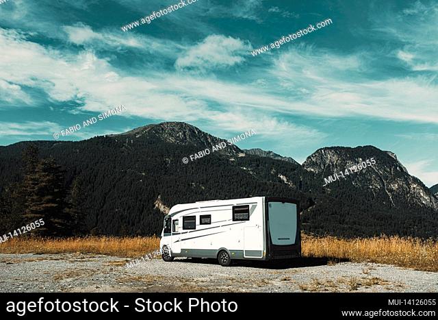 motorhome camper vehicle for transport and vacation parked near mountains, enjoying outdoors in travel and lifestyle