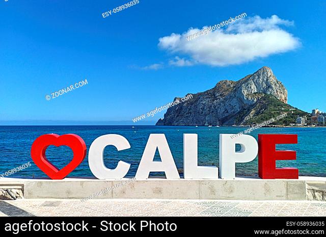 Calpe big letters with red heart shape as symbol of landmark place for tourists at seafront promenade, Penyal d'Ifac Natural Park and Mediterranean Sea view on...