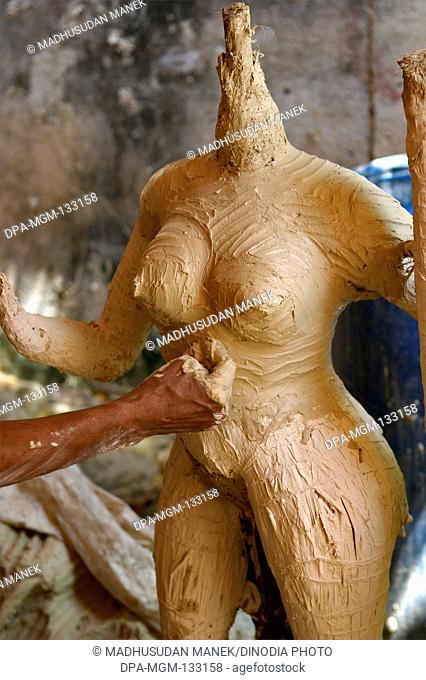 Sculptor making goddess Durga Kali sculpture using of clay for Durga Pooja preparation ; Rajkot ; Gujarat; India