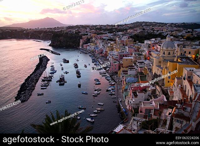 View of the Port of Corricella with lots of colorful houses in the sunset, Procida Island, Italy