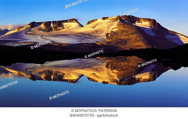 Early-morning light on the Fannaraken peaks with a mirror-like reflection in a glacial lake, Norway, Jotunheimen NP