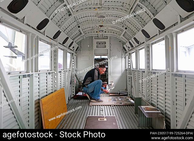 17 May 2023, Saxony-Anhalt, Wernigerode: Mathias Kögler from the Wernigerode Aviation Museum examines the fuselage of a Ju 52 that has recently become part of...