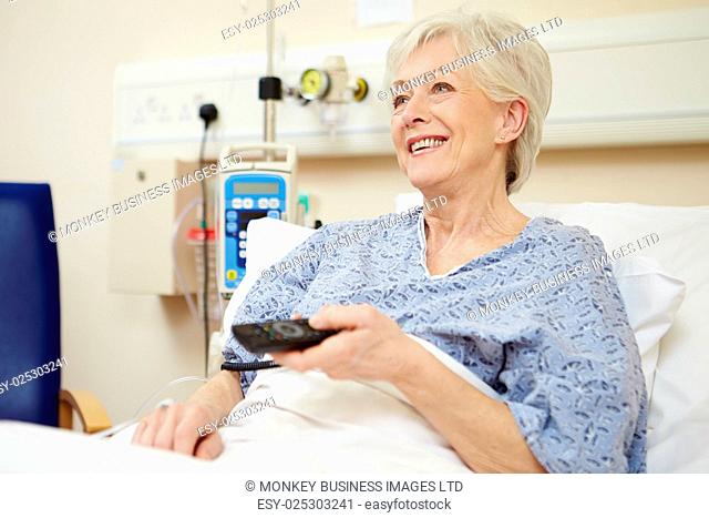 Senior Female Patient Watching TV In Hospital Bed