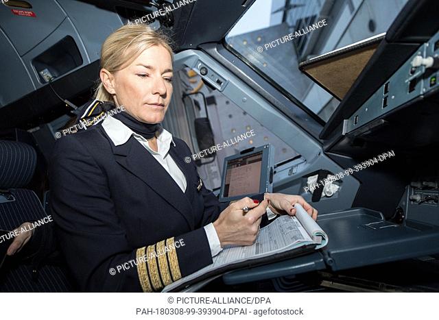 08 March 2018, Germany, Frankfurt: Riccarda Tammerle, rflight captain, making some last minute checks in the Lufthansa Airbus A 321 before its flight to Berlin