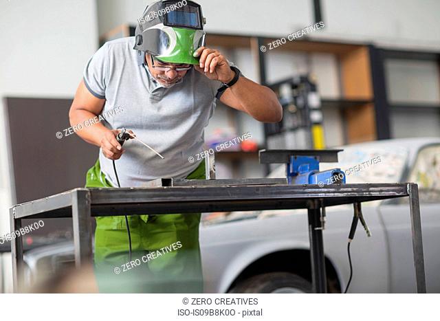 Man welding in bodywork repair shop