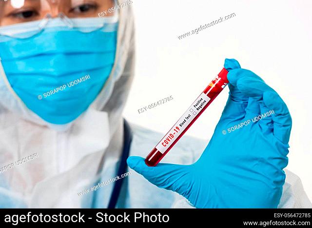 Medical scientist in PPE uniform wear a mask holding test tube Coronavirus test blood sample in a hospital laboratory for analyzing isolated on white