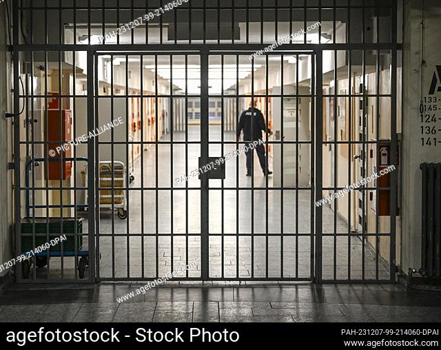 07 December 2023, Berlin: A prison officer opens a cell door in a cell corridor secured with bars at Moabit Prison during the presentation of plans for a...