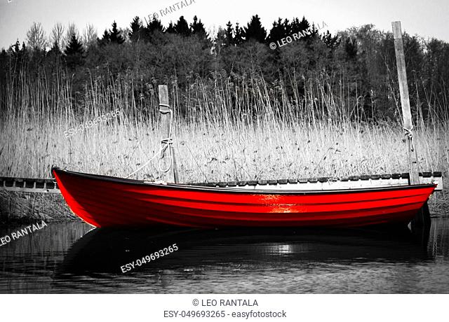 Red rowing boat otherwise in black and white picture. The picture is taken in Kotka, Finland