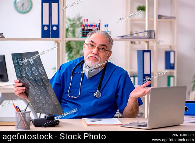 Old male doctor working in clinic