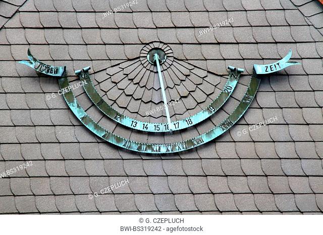 copper sun dial at the slate facade of a building, Germany