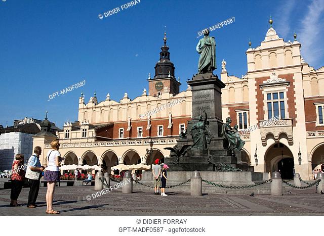 TOURISTS LOOKING AT THE STATUE OF THE POLISH ROMANTIC POET ADAM MIECKIEWICZ IN FRONT OF THE BEDCOVER MARKET SUKIENNICE AND THE TOWER OF THE CITY HALL WIEZA...