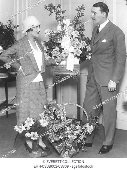 Newly married Gloria Swanson and Marquis de la Falaise, at the Ritz Carlton Hotel in New York City. Many floral pieces greeted her return from France in Nov