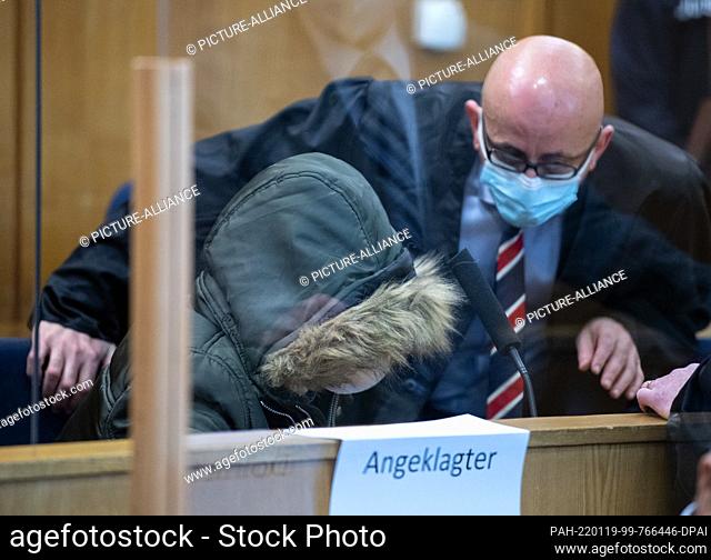 19 January 2022, Hessen, Frankfurt/Main: The accused doctor (l, front), who comes from Syria, sits in the security room of the Higher Regional Court in...