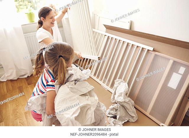 Mother and daughter building cot