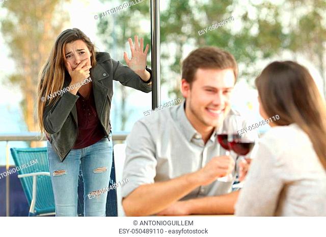 Cheater caught by his sad girlfriend dating with another girl in a coffee shop