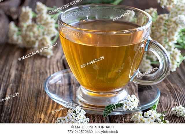 A cup of herbal tea with fresh yarrow flowers