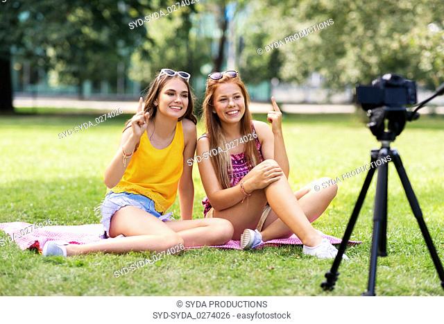 teenage bloggers recording video by camera in park