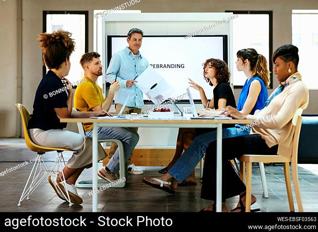 Business colleagues having discussion together at desk