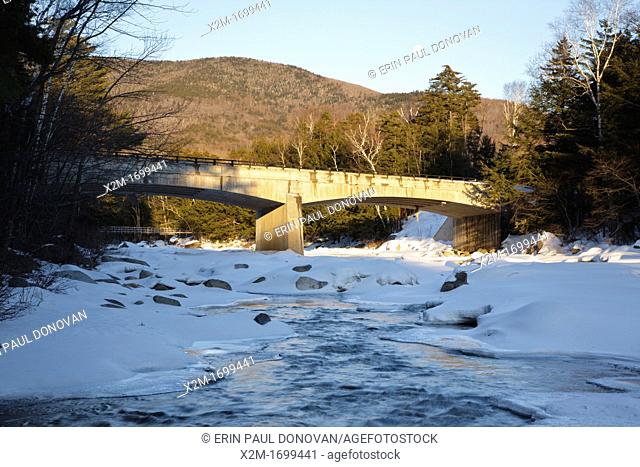 Road Bridge during the in winter months  This bridge crosses the East Branch of the Pemigewasset River in Lincoln, New Hampshire USA along Kancamagus Scenic...