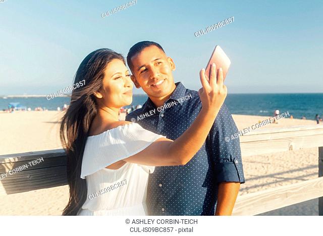 Couple beside beach, talking selfie, using smartphone, Seal Beach, California, USA