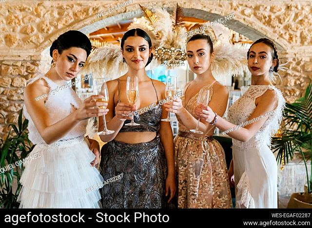 Beautiful women holding champagne flute while standing at banquet