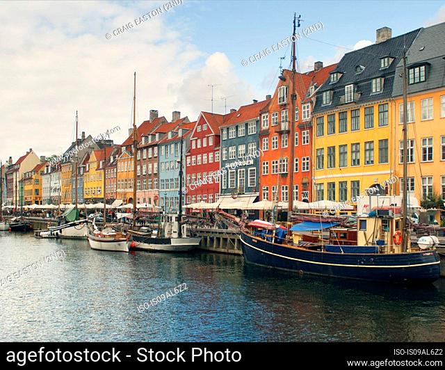 Sailing boats, sidewalk restaurants and colorful townhouses, Nyhavn harbor, Copenhagen, Denmark