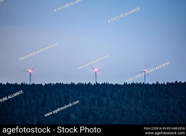 SYMBOL - 15 August 2023, Baden-Württemberg, Spaichingen: Wind turbines rotate in the dark at a wooded area. Photo: Silas Stein/dpa