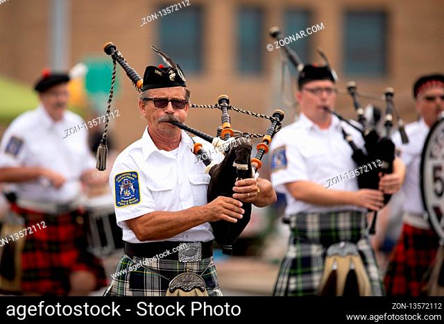 Peru, Indiana, USA - July 21, 2018 Men from the Indianapolis 500 Gordon Pipers Horse Shoe Pipes and Drums playing bagpipes at the Circus City Festival Parade