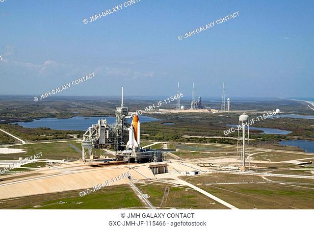 On Launch Pad 39A at NASA's Kennedy Space Center in Florida, space shuttle Discovery awaits the liftoff of its final scheduled mission