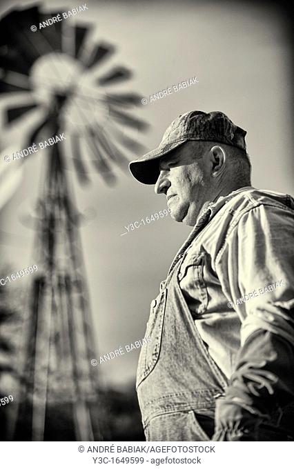 Portrait of American Farmer Vintage Style Black and White with Ranch Windmill in Background