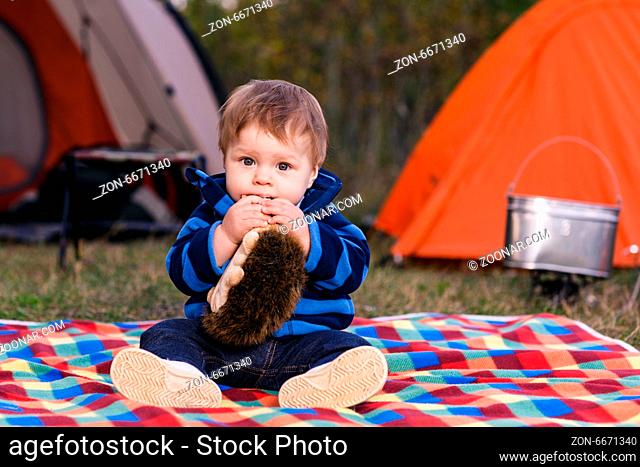 little boy playing with a teddy bear in the grass