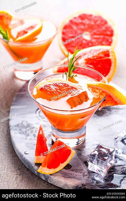 Fresh pink grapefruit drink with juice. Cold summer citrus refreshing drink or beverages with rosemary