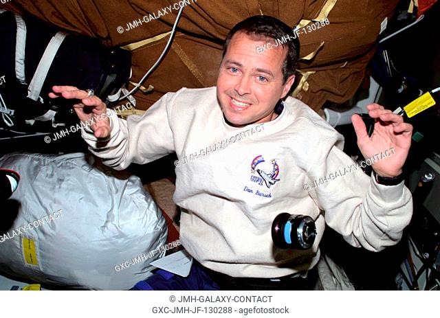 Astronaut Daniel W. Bursch, Expedition Four flight engineer, is photographed with stowage bags on the mid deck of the Space Shuttle Endeavour
