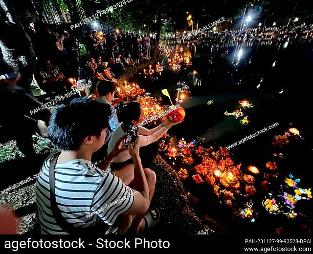 27 November 2023, Thailand, Bangkok: Thais pray at a lake in Lumphini Park, one of Bangkok's largest parks, before putting their krathong into the water