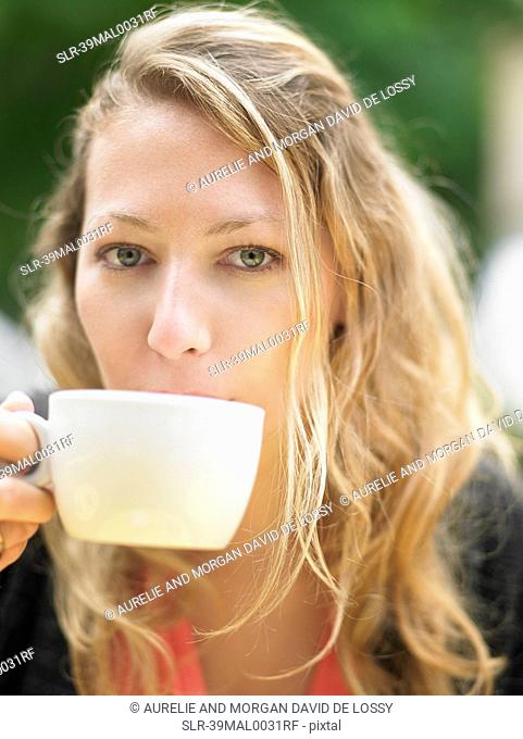 Woman having coffee at sidewalk cafe