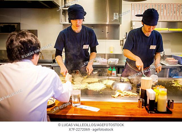 Chef Cooking Okonomiyaki, in a restaurant of Okonomi-mura, Hiroshima, Japan