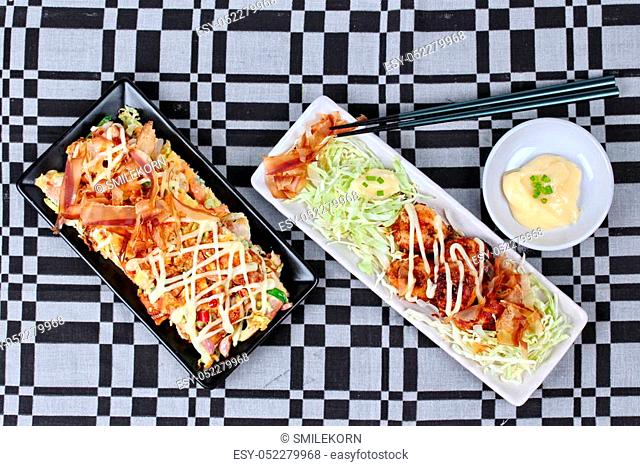 Japan pizza as ""Okonomiyaki"" is fried mixed vegetable flour with meat and A dish grill flour wrap squid as ""Takoyaki"", topped sweet sauce