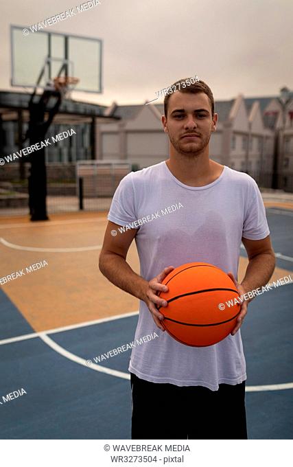 Man holding a basketball standng in playground