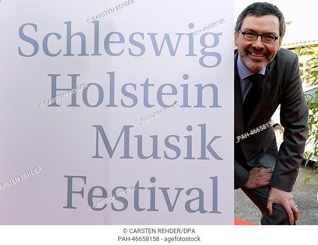 New artistic director of classical musical festival Schleswig-Holstein Musik Festival (SHMF), Christian Kuhnt, stands next to a poster for the festival in...
