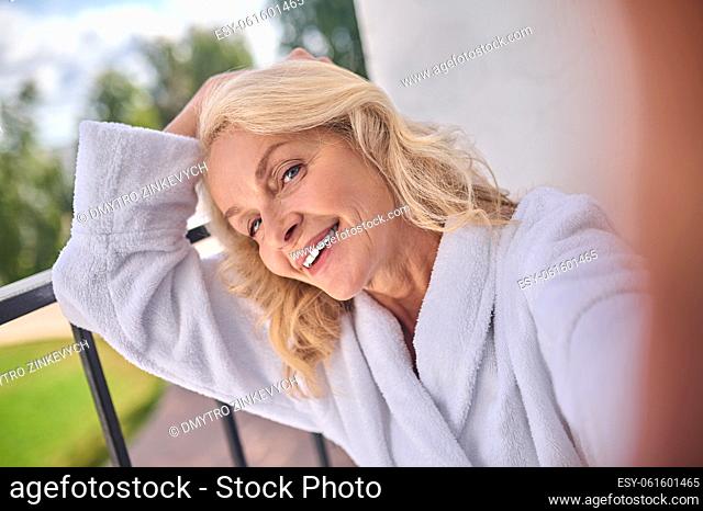 Selfie. A blonde woman in a white robe posing for the photo