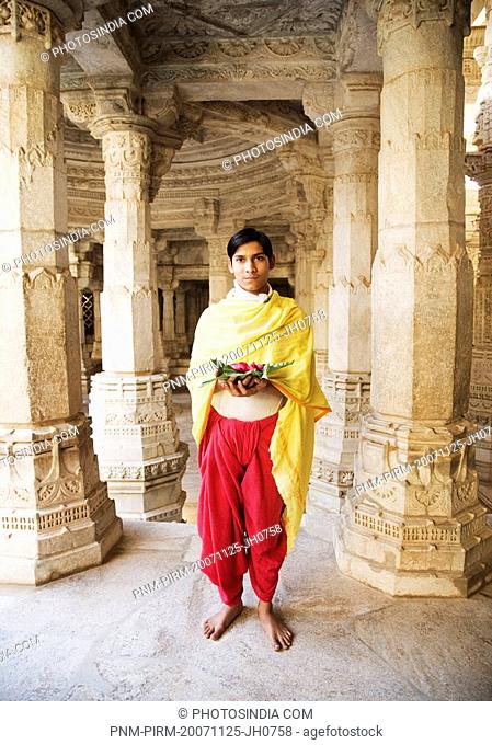Teenage boy holding religious offering in a temple, Adinath Temple, Jain Temple, Ranakpur, Pali District, Udaipur, Rajasthan, India