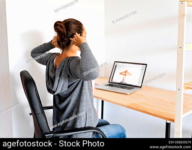 Woman doing stretching yoga at her office by online sport video. Fitness at work. . High quality photo