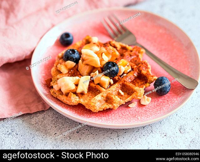 Easy healthy gluten free oat waffles with copy space. Appetizing homemade waffles with oat flour decorated blueberries, on plates over light gray cement...