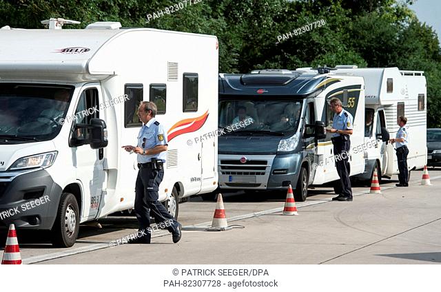 Police officers inspect camper vans by the A5 highway near Neuenburg,  Germany, 22 July 2016. Because many campers and trailers are overloaded during summer